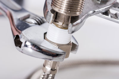 Photo of professional plumber fixing a leak